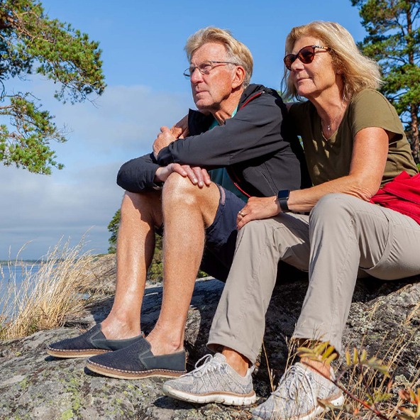 Older couple sitting on a rock out in nature